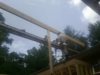 Carpenter setting a ridge beam over a new addition frame — Ice Dam Removal by Roofing Brothers in Geyserville